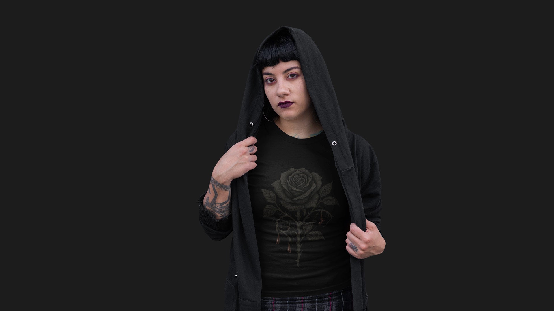 Woman in black hoodie revealing gothic rose t-shirt, standing against dark background – moody Halloween banner for Gothic & Dark Aesthetic apparel collection.